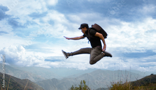 Turista con gorra y mochila Saltando hacia lo Desconocido Aventura en la Naturaleza, concepto de viaje éxitos ,libertad   © Yoel Garay