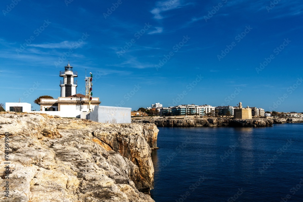 view of the Ciutadella llighthouse and Sant Nicolau Castle at the harbour entrance in Ciutadella