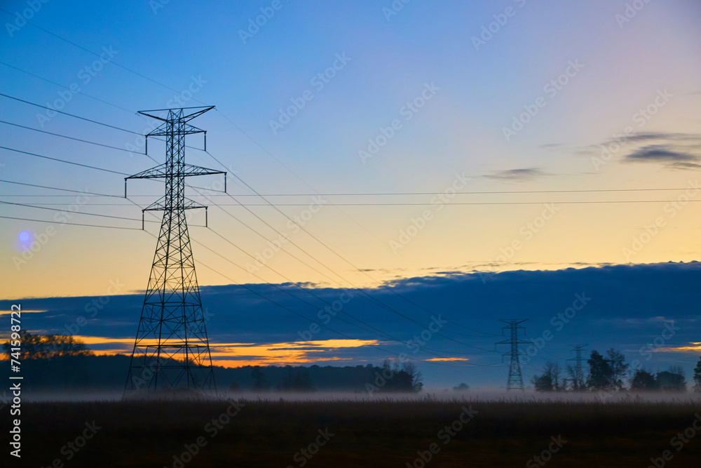 Sunrise Over Foggy Fields with Electricity Pylons in Rural Michigan