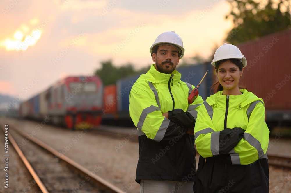 Male and Female engineers with geen safety jackets working at train station Male and Female engineers with geen safety jackets working at train station