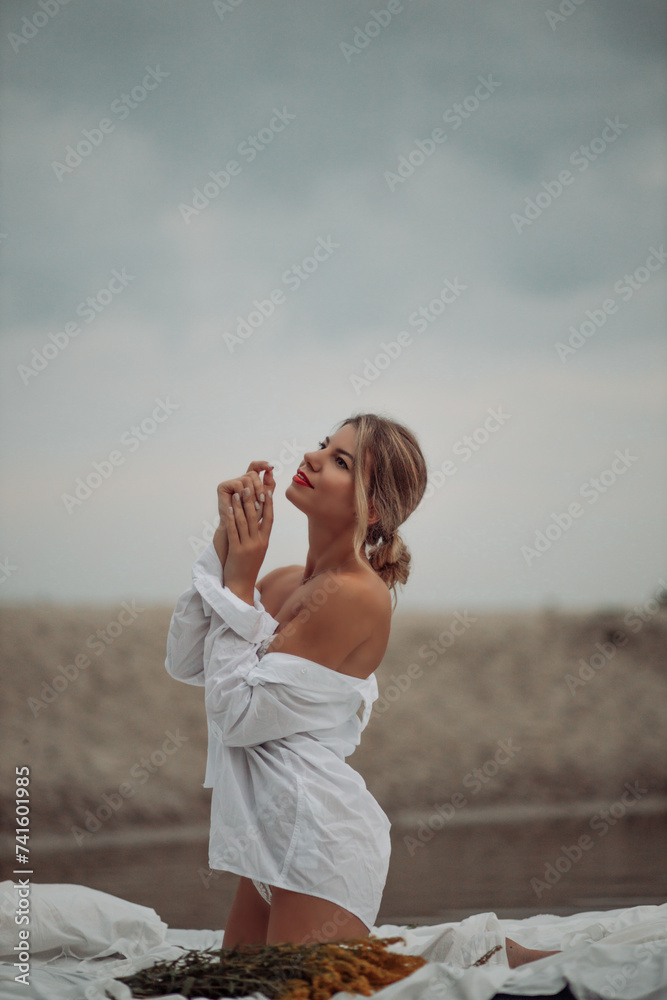 Beautiful girl on the shore of the lake in white underwear and a shirt. Beautiful girl on the shore of the lake in white underwear and a shirt.