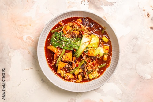 Bowl of red curry with vegetables and tofu on white background photo