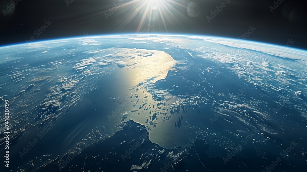 Fototapeta premium The sun rises over the Earth's curvature, illuminating the planet's varied terrain and vast oceans from space.