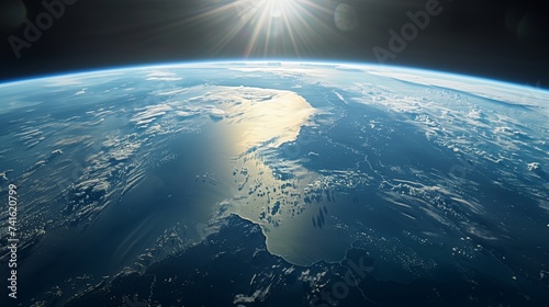 The sun rises over the Earth's curvature, illuminating the planet's varied terrain and vast oceans from space.