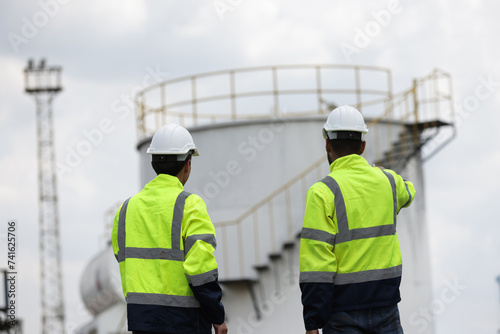 Railway engineers or technicians wearing safety jackets and safety PPE work maintenance service at chemical storage 