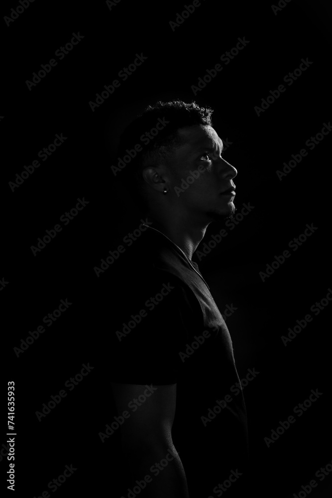 Low key of young African American man in profile. black and white photography