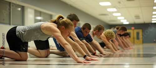 Group of young adult sporty people training together in fitness center working out at animal flow style making crab position. with copy space image. Place for adding text or design