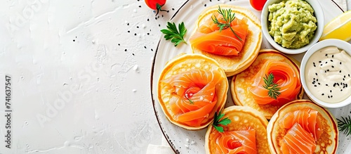 Mini blini pancakes with soft cheese cold smoked salmon and guacamole. with copy space image. Place for adding text or design photo