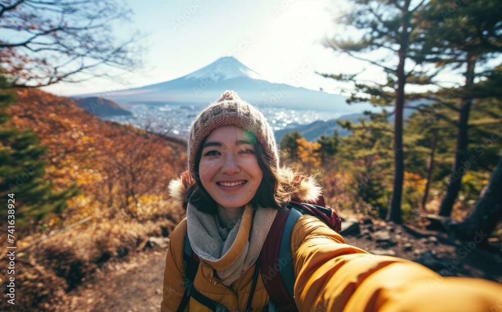 Naklejka premium Fuji Explorer: An Influencer's Odyssey - A Young Woman Chronicles Her Adventure with a Backpack Selfie near Mount Fuji in Tokyo, Japan, Embracing Nature's Spectacle.