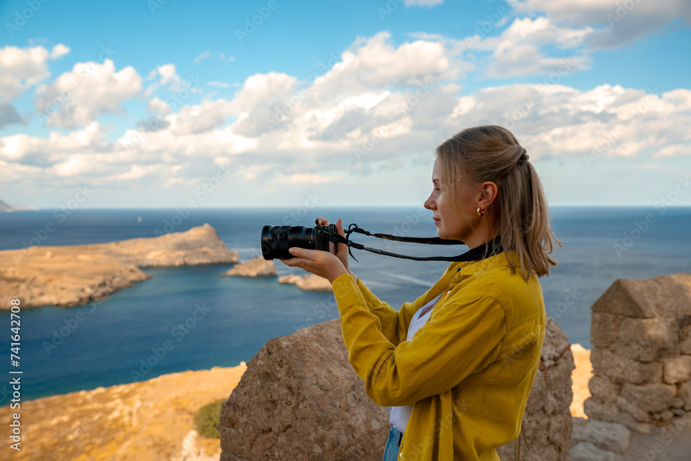 A woman photographer takes pictures of Lindos Bay. A woman photographer takes pictures of Lindos Bay.