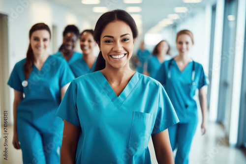 A group of happy female doctors in blue scrubs.