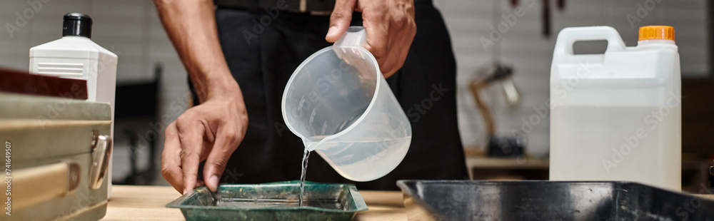 Obraz premium process of film development, banner of african american man pouring chemical solution in tray
