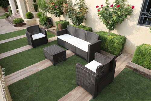 Modern garden furniture set of rattan inside the patio of the house photo