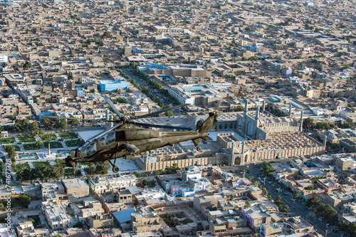 Herat, Afghanistan - 07 June 2014: Aerial view of an A129 'MANGUSTA' helicopter of the Italian Army with anti-tank functions, Masjid i Jami Mosque in Herat, Afghanistan. photo