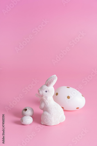 White rabbit and eggs symbol for Easter on a pink background background