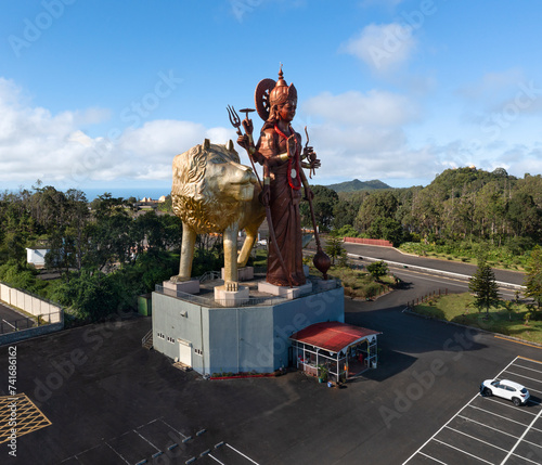 Aerial drone view of the gigantic statue of Hindu goddess Durga Maa Bhavani with golden lion overlooking the entrance of the holy site, Grand Bassin, Savanne, Mauritius. photo