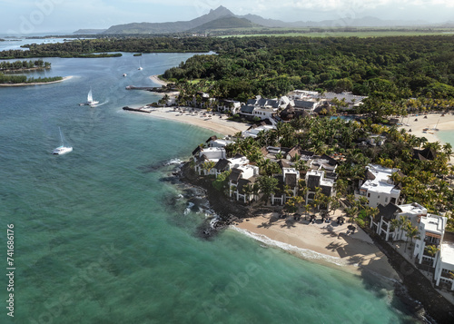 Aerial drone view of 5 star resort Shangri - La Le Touessrok with sandy beach, white villas, sailing boats and mountain range in the background, Ilot Lievres, Flacq, Mauritius. photo