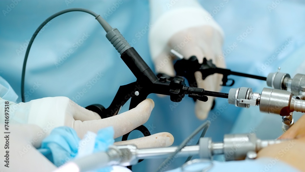 Hands of surgeons with the help of endoscopic equipment and instruments