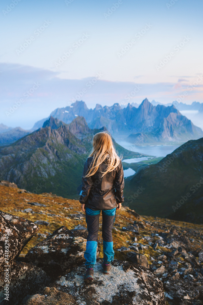 Woman solo traveler hiking in Norway exploring mountains of Lofoten islands tourist traveling outdoor alone healthy lifestyle summer vacations adventure extreme tour - obrazy, fototapety, plakaty 