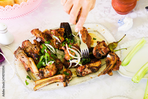 Canvas Print various shish kebabs, greens, salad of fresh tomatoes and cucumbers on the table, national, Eastern dishes