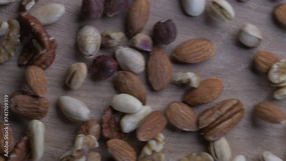 Display of Mixed Nuts Gliding Across a Table, macro close-up overhead view Display of Mixed Nuts Gliding Across a Table, macro close-up overhead view