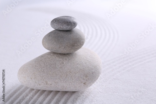 Zen garden stones on white sand with pattern  closeup