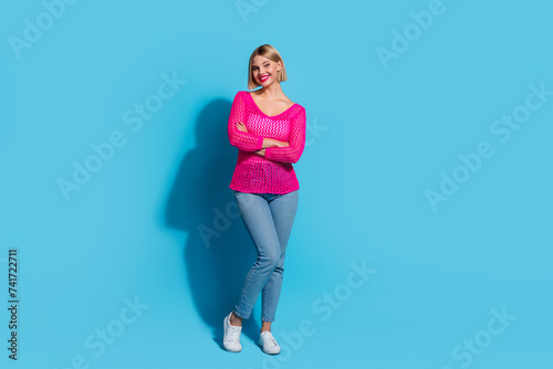 Full body photo of attractive young woman crossed hands confident pose wear trendy pink knitted clothes isolated on blue color background © deagreez