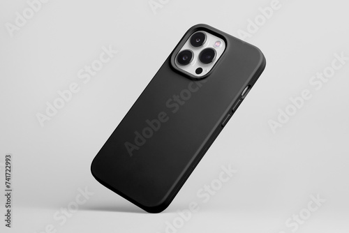 iPhone 15 Pro in black soft silicone case falls down back view, smartphone mockup isolated on grey background