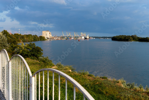 View of harbor cranes and cargo ships at port of Izmail in the Danube river photo