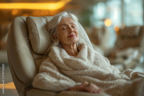 Senior woman lying down on lounge chair at health spa photo