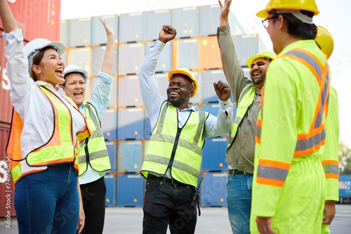 group of workers or engineer feeling happy and raising hands up from success work in containers warehouse storage