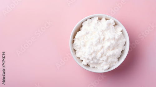 Cottage cheese in a bowl on pink background with copy space