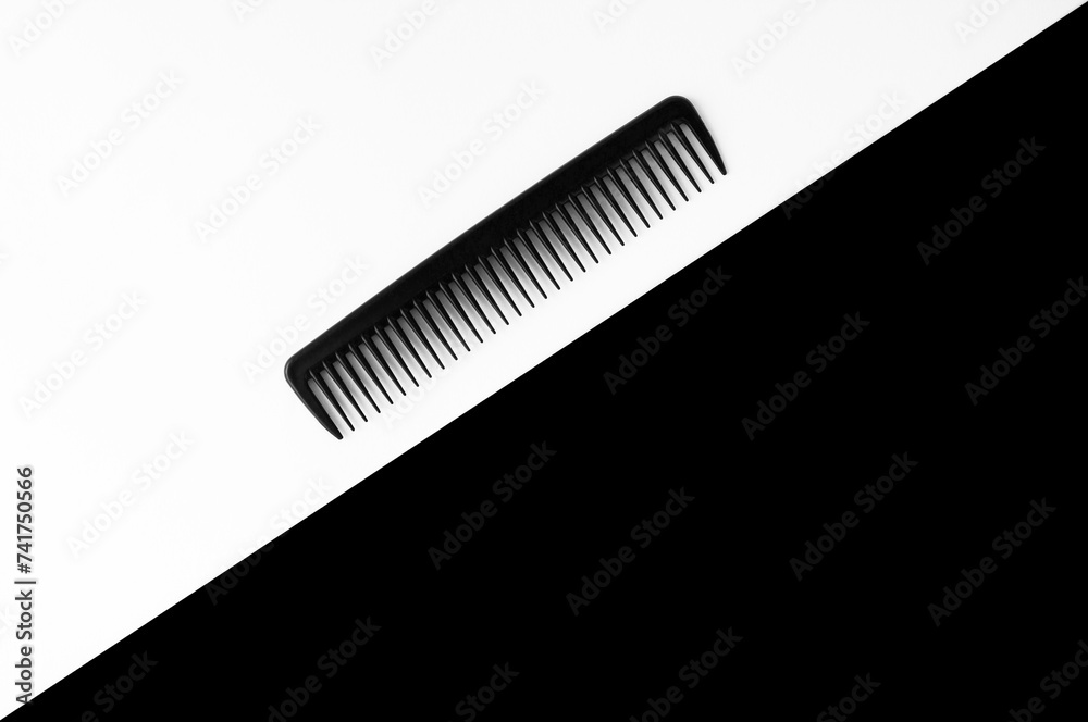 Black comb on the white and black background.Top view. Copy space. Black comb on the white and black background.Top view. Copy space.