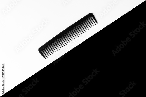 Black comb on the white and black background.Top view. Copy space.