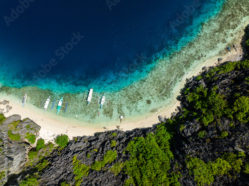 Top view of Talisay Beach and boats floating over clear sea warer. Tapiutan Island. El Nido, Philippines. photo