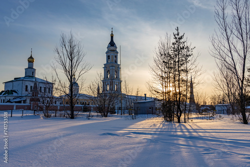 Winter landscape at sunset, frosty evening, view of ancient Slavic architecture.