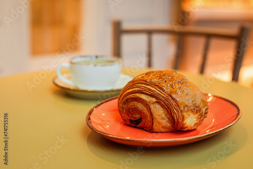 Freshly baked pain au chocolat pastry and a cup of coffee
