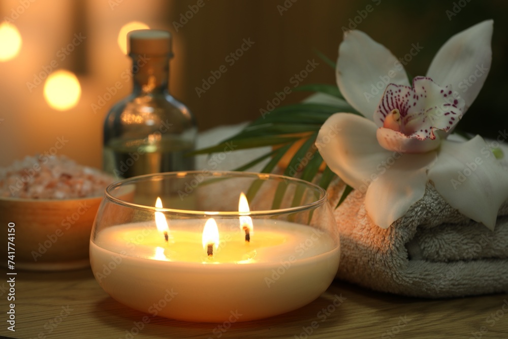 Beautiful spa composition with burning candle on wooden table, closeup