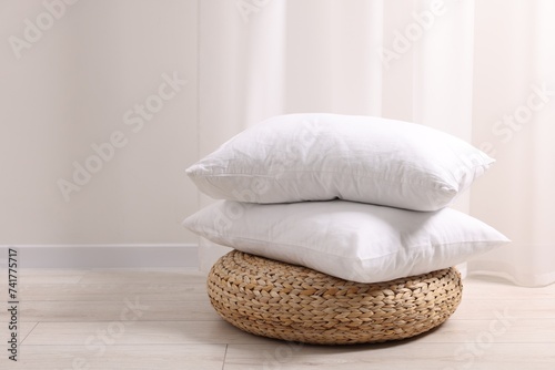 Fototapeta Naklejka Na Ścianę i Meble -  Soft pillows on wicker pouf in room, space for text