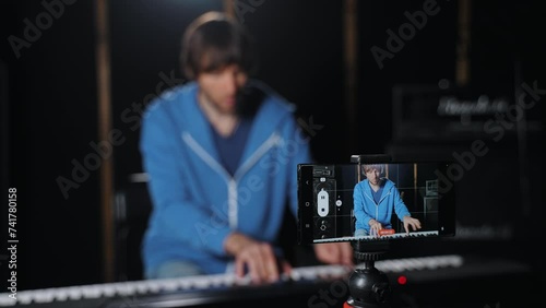 A talented virtuoso piano player and blogger is capturing his beautiful concert on mobile device, or streaming it online on a media platform for his audience to enjoy and appreciate. 4K footage