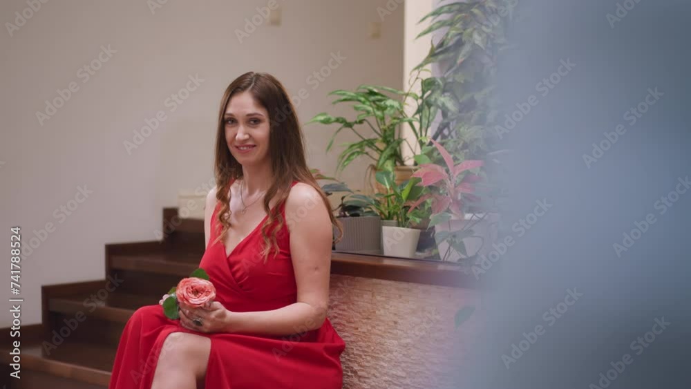 Flirting woman poses for artist in studio. Seductive woman in red slit dress holds rose inspiring painter to draw in art shop. Live model for master Flirting woman poses for artist in studio. Seductive woman in red slit dress holds rose inspiring painter to draw in art shop. Live model for master
