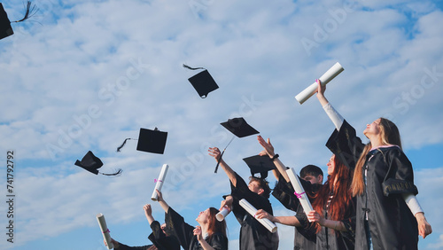 Photography Happy college graduates tossing their caps up at sunset.