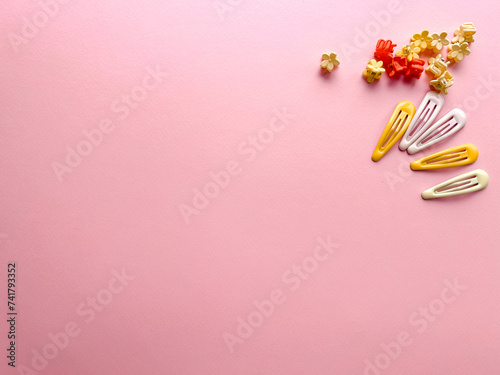 A set of accessories for a little girl on a pink background. Hairpins, comb, hair bands. Fashionable hair accessories for little girls. Flat styling. Top view photo