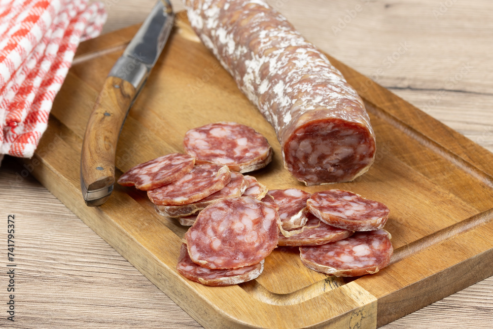 saucisson sec tranché, en gros plan, sur une planche à découper