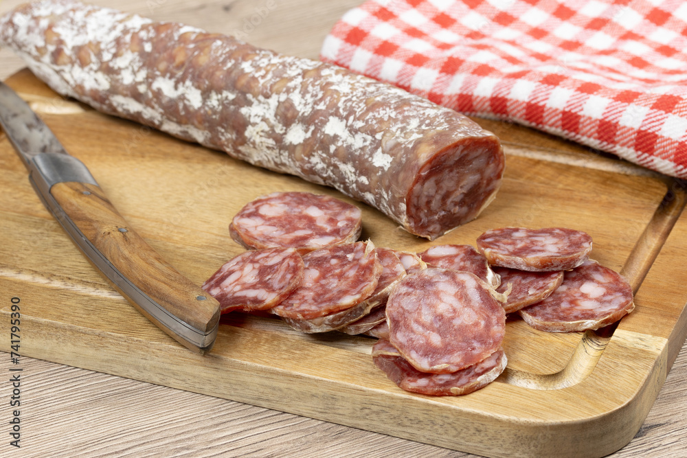saucisson sec tranché, en gros plan, sur une planche à découper saucisson sec tranché, en gros plan, sur une planche à découper