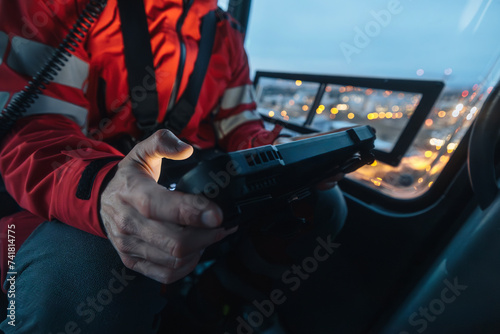 Close-up of hands of doctor inside helicopter emergency medical service while using digital tablet during a night mission flight.. photo