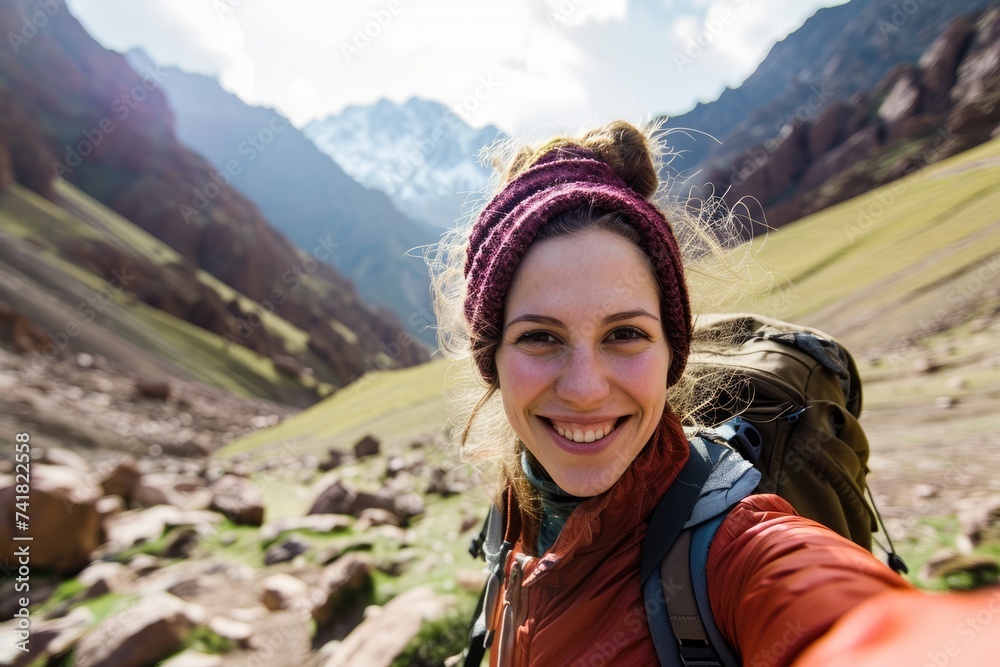 Mountain Memories: Joyful Traveler with Backpack Snaps Selfie against Toubkal Peak, Reveling in the Spectacular Scenery of Morocco's High Atlas Range.