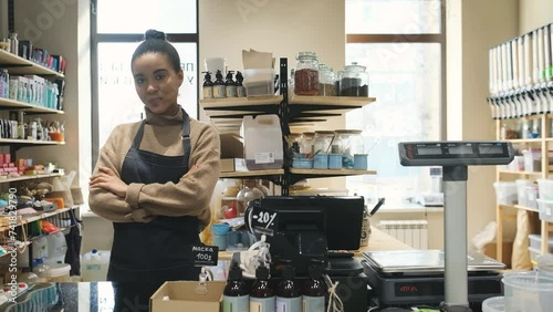 Portrait of happy African American woman owner of local zero waste grocery store at cash desk photo