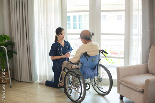 Young asian female nurse care giver helping asian senior old man in living area of nursing home senior daycare center, Nurse take care elderly patient with cheerful concentrate, health insurance photo