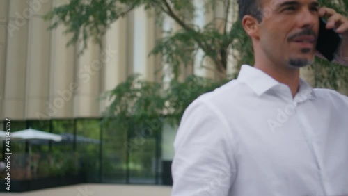 Wallpaper Mural Office worker talking smartphone strolling modern city closeup. Man calling Torontodigital.ca